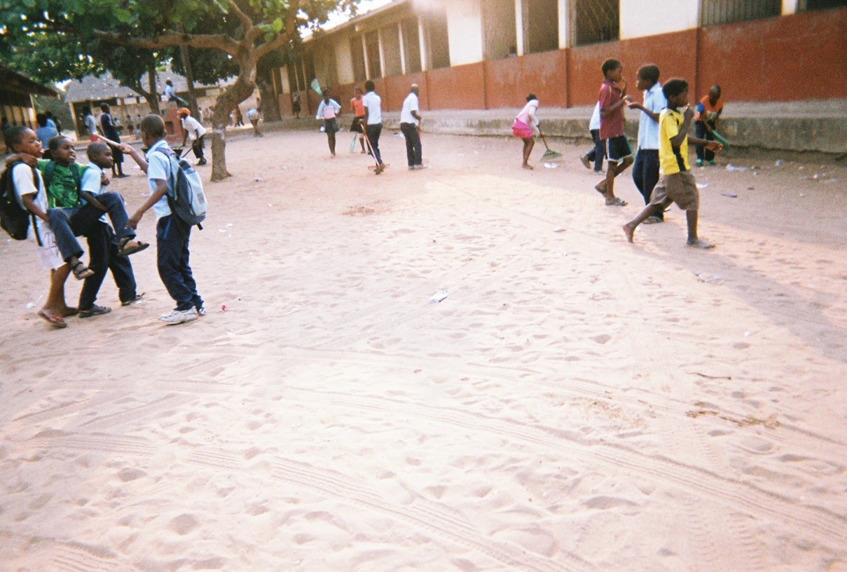 Die Schüler sehen glücklich und zufrieden aus. Sie spielen auf einem sauberen Schulhof.