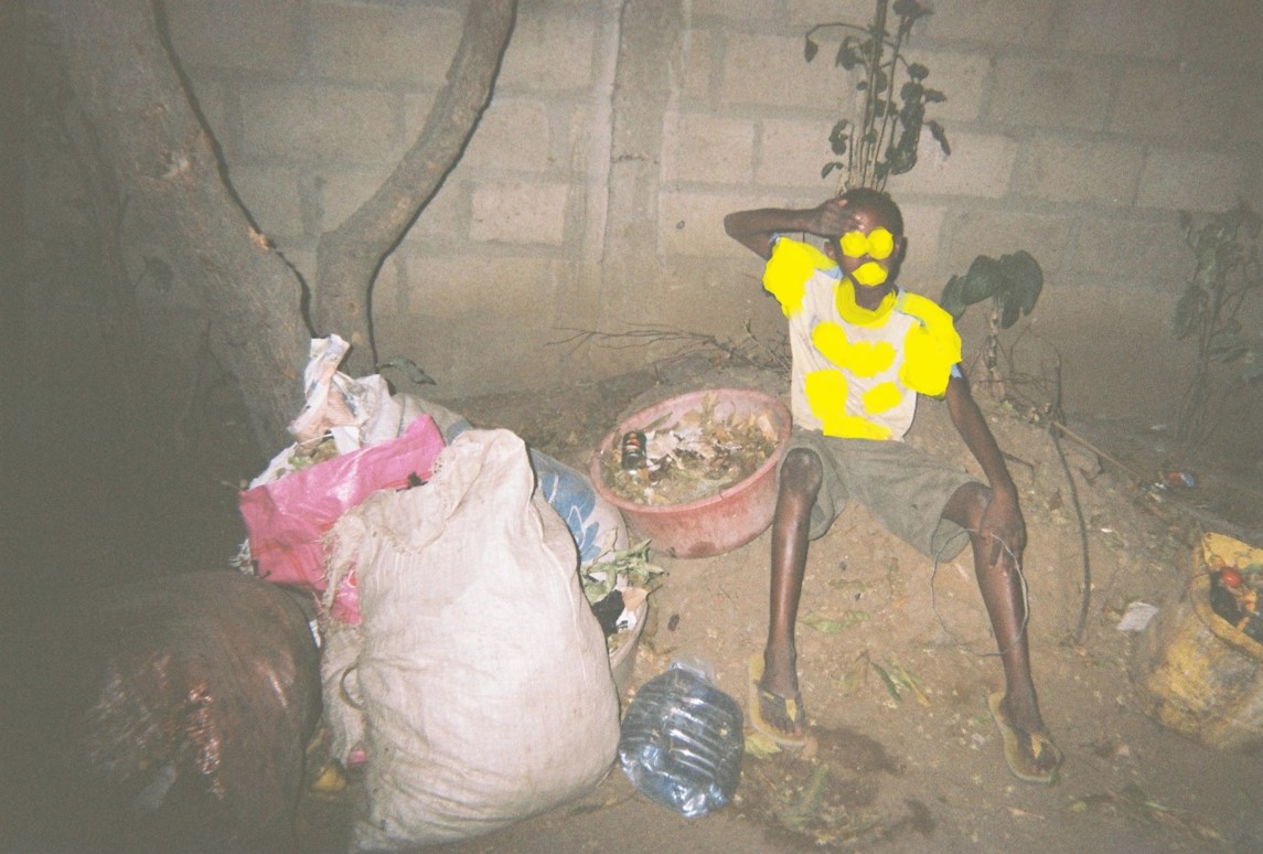 Ein Kind sitzt direkt neben Müll. Hier gibt es keine Müllabfuhr. Das ist ein unsicherer Ort.