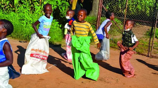 Simbabwe: Kinder spielen Sackhüpfen.