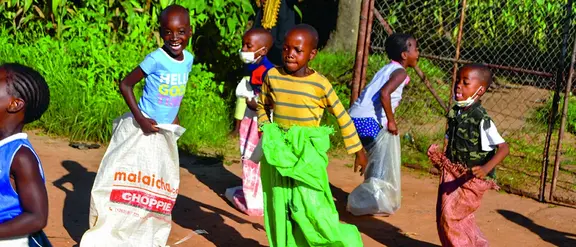 Simbabwe: Kinder spielen Sackhüpfen.