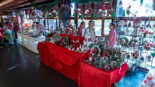 Stand con adornos navideños y dos voluntarios