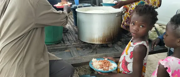 Ein Mädchen steht an der Essensausgabe für Opfer der Überschwemmungen.