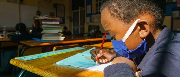 Südafrika: Ein Kind lernt konzentriert in der Schule.