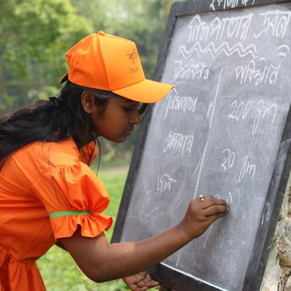 Tanushree, ein 17-jähriges Mädchen aus dem Dorf Sikharbali, schreibt die Zutaten für das Schädlingsbekämpfungsmittel an die Tafel.