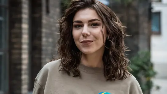 Eine Frau steht mittig im Bild und schaut in die Kamera