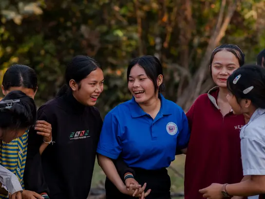 Vier junge Frauen aus Kambodscha lachen und sprechen miteinander.