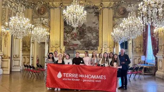 Das Bild zeigt Schülerinnen und die Lehrerin der Janusz-Korczak-Gesamtschule Neuss und Gerd Faruß von der Terre des Hommes-Gruppe Neuss/Düsseldorf