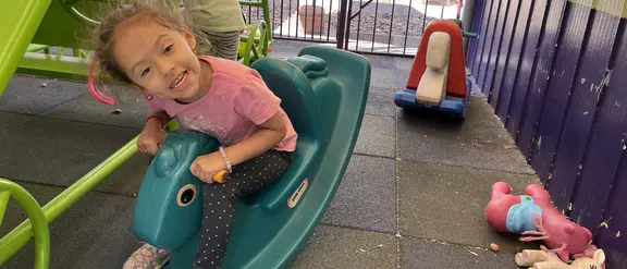 A young girl on a swinging playground device