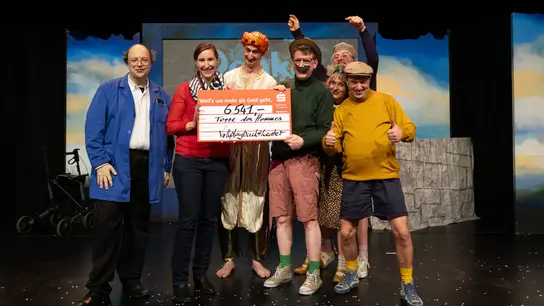 Mitglieder des Vollplaybacktheaters überreichen einen Scheck an Terre des Hommes