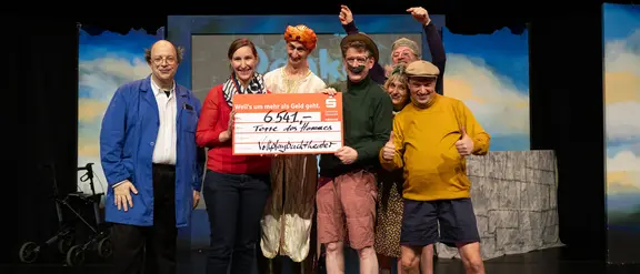Mitglieder des Vollplaybacktheaters überreichen einen Scheck an Terre des Hommes