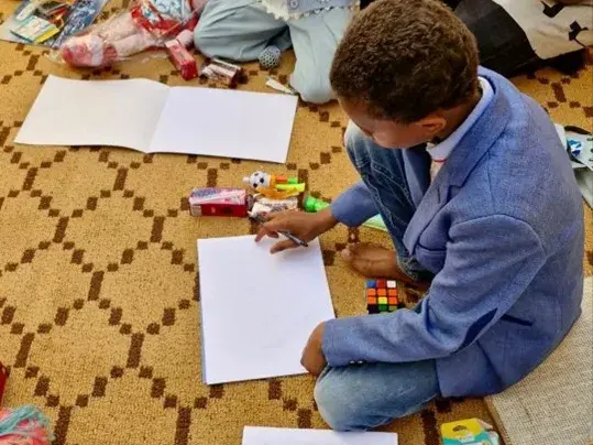 Kinder sitzen auf dem Boden und malen