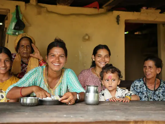 Eine Gruppe von Frauen und Kindern sitzt an einem Tisch.