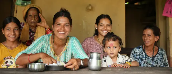 Eine Gruppe von Frauen und Kindern sitzt an einem Tisch.