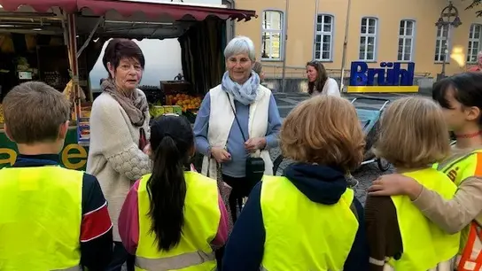 Schulkinder verteilen Blumen als Dank für Spende