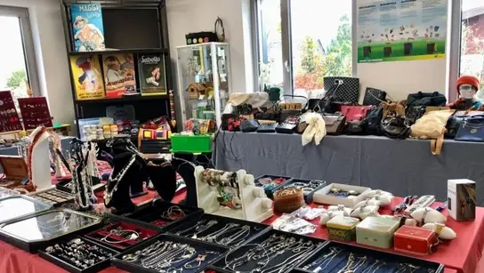 Tische, auf denen Schmuck, Kleidung und Bücher platziert sind