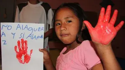 Das Bild zeigt ein kolumbianisches Mädchen mit einer rot angemalten Hand anlässlich des Red Hand Days