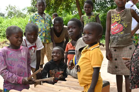 Sechs Kinder aus dem Südsudan posieren für ein Gruppenbild. Sie sind draußen und haben bunte Kleidung an.