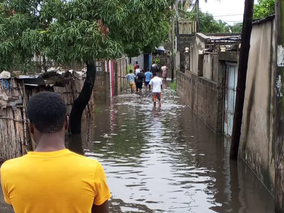 Ein Mann in einem gelben T-Shirt schaut auf eine Gasse, die nach schweren Überschwemmungen in Mosambik überflutet ist.