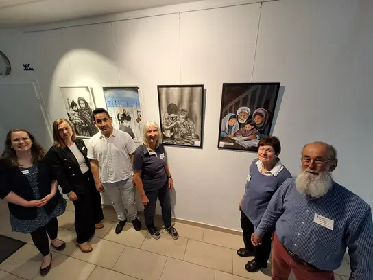 Mitglieder der Gruppe vor Ausstellungsbildern
