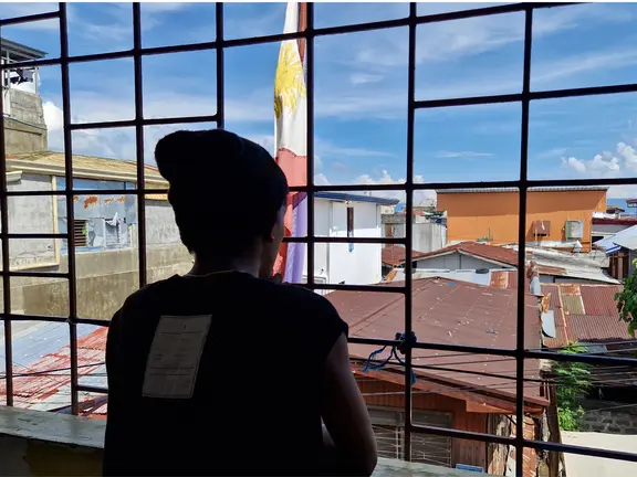 Matikas*, 16, looks out over his neighborhood in Davao.