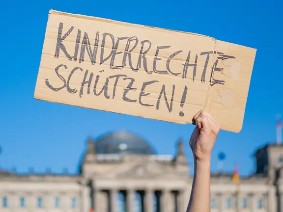 Ein Schild mit der Aufschrift "Kinderrechte schützen"
