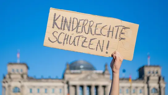 Ein Schild mit der Aufschrift "Kinderrechte schützen"