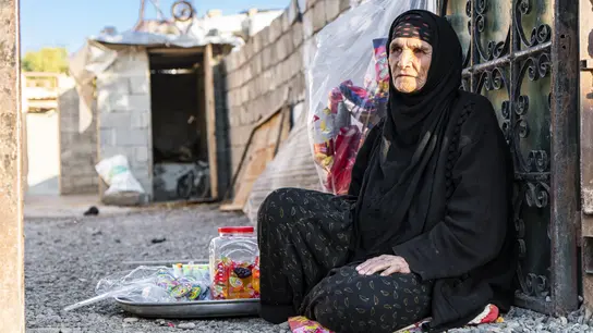 Rechts: Eine geflüchtete Frau versucht, in Mosul mit dem Verkauf von Süßigkeiten etwas Geld zu verdienen.