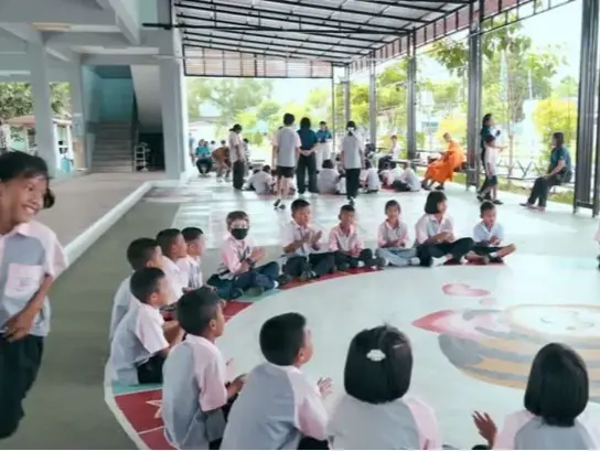 Kinder sitzen im Kreis und spielen ein Spiel