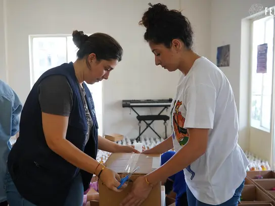 FEMALE staff pack boxes with emergency relief supplies
