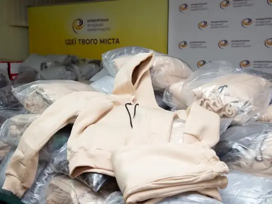 Ein Jogginganzug liegt auf Paketen mit weiteren eingepackten Jogginganzügen