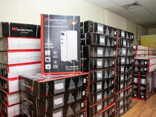 Ein Stapel mit neu verpackten Öl-Heizkörpern liegt an einer Wand