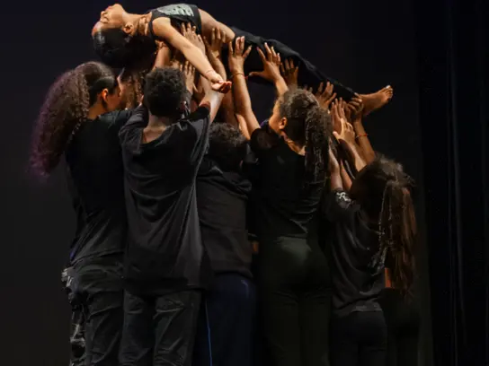 Kinder tragen eine Person bei einer Aufführung