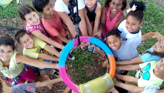 Das Bild zeigt Kinder im Projekt CEDECA in Brasilien, die in der Mitte einen Ring halten