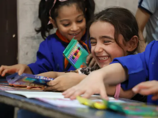 Zwei lachende Mädchen beim malen