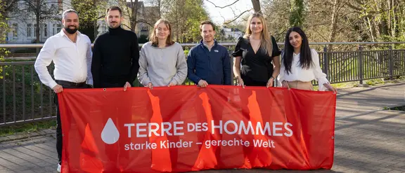 Auf dem Bild sind die Terre des Jeunes-Sprecherinnen und Sprecher 2025 mit einem Banner in der Hand zu sehen.