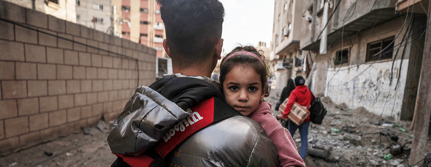 Ein Junge trägt ein kleines Mädchen im Gaza-Streifen