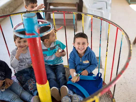 Niños de un jardín de infancia en Jerusalén Este juegan en un carrusel.