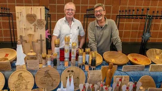 zwei Künstler hinter einem Tisch mit gefertigten Kunsthandwerk