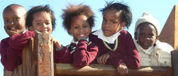 Südafrika: Eine Kindergruppe klettert auf einem Klettergerüst. 