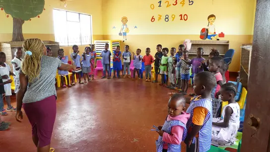 Kinder stehen in einem Kreis in einer Schule in Mosambik. 