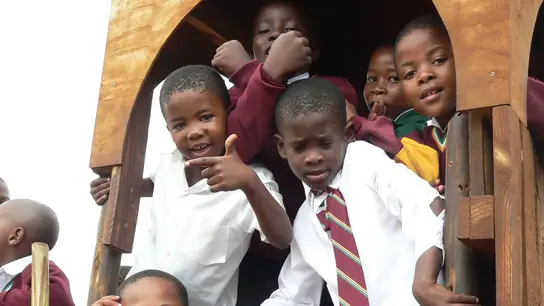 Südafrika: Eine Kindergruppe klettert auf einem Klettergerüst.