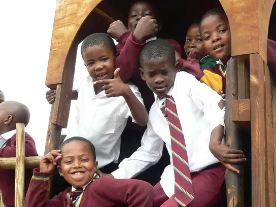Südafrika: Eine Kindergruppe klettert auf einem Klettergerüst.